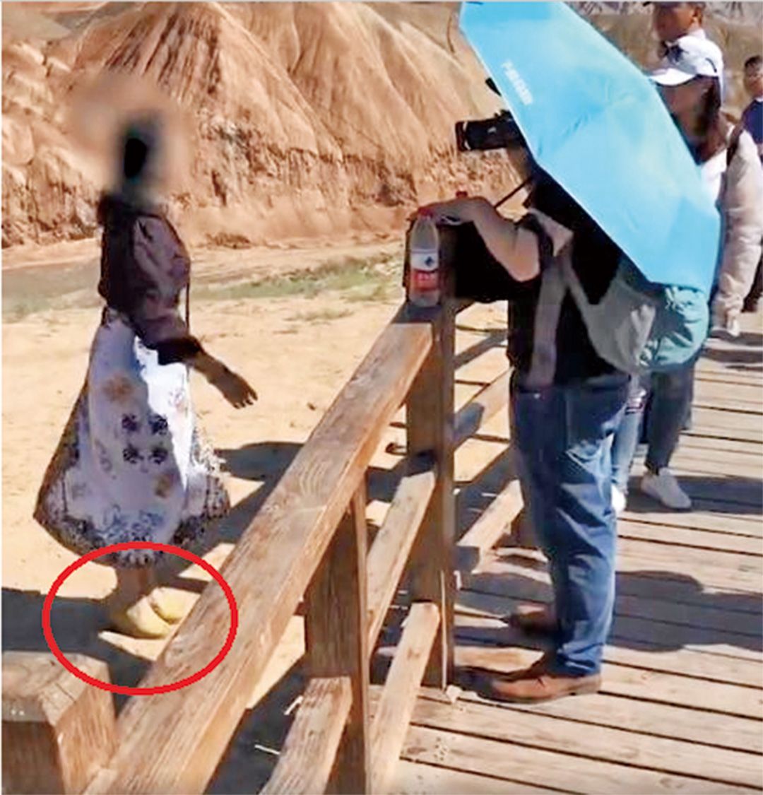 女遊客踩丹霞地貌拍照